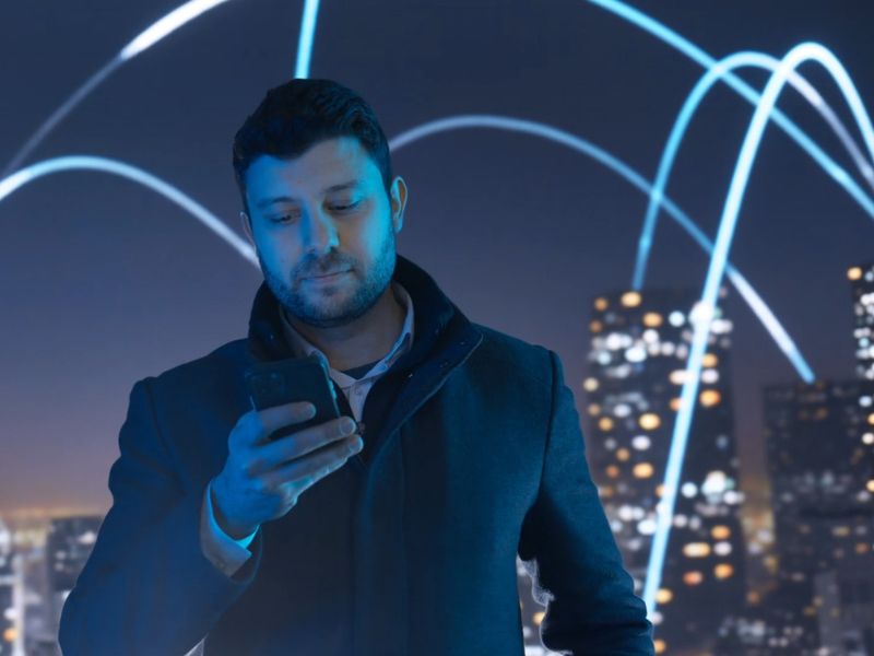 Muška osoba u kaputu koristi 5G internet