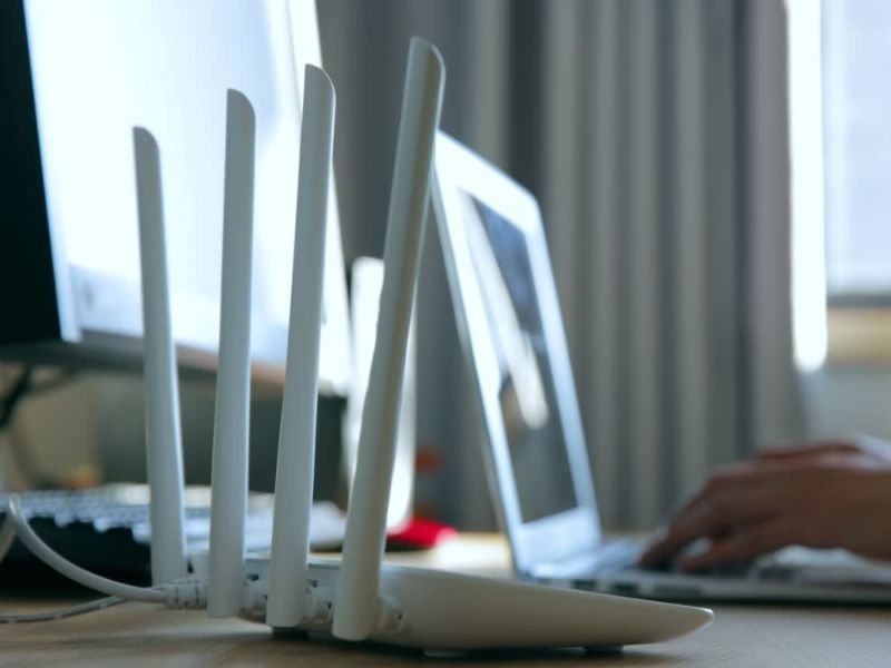 Prikaz dnevne sobe u kojoj je glavni fokus na internet ruteru i laptopu